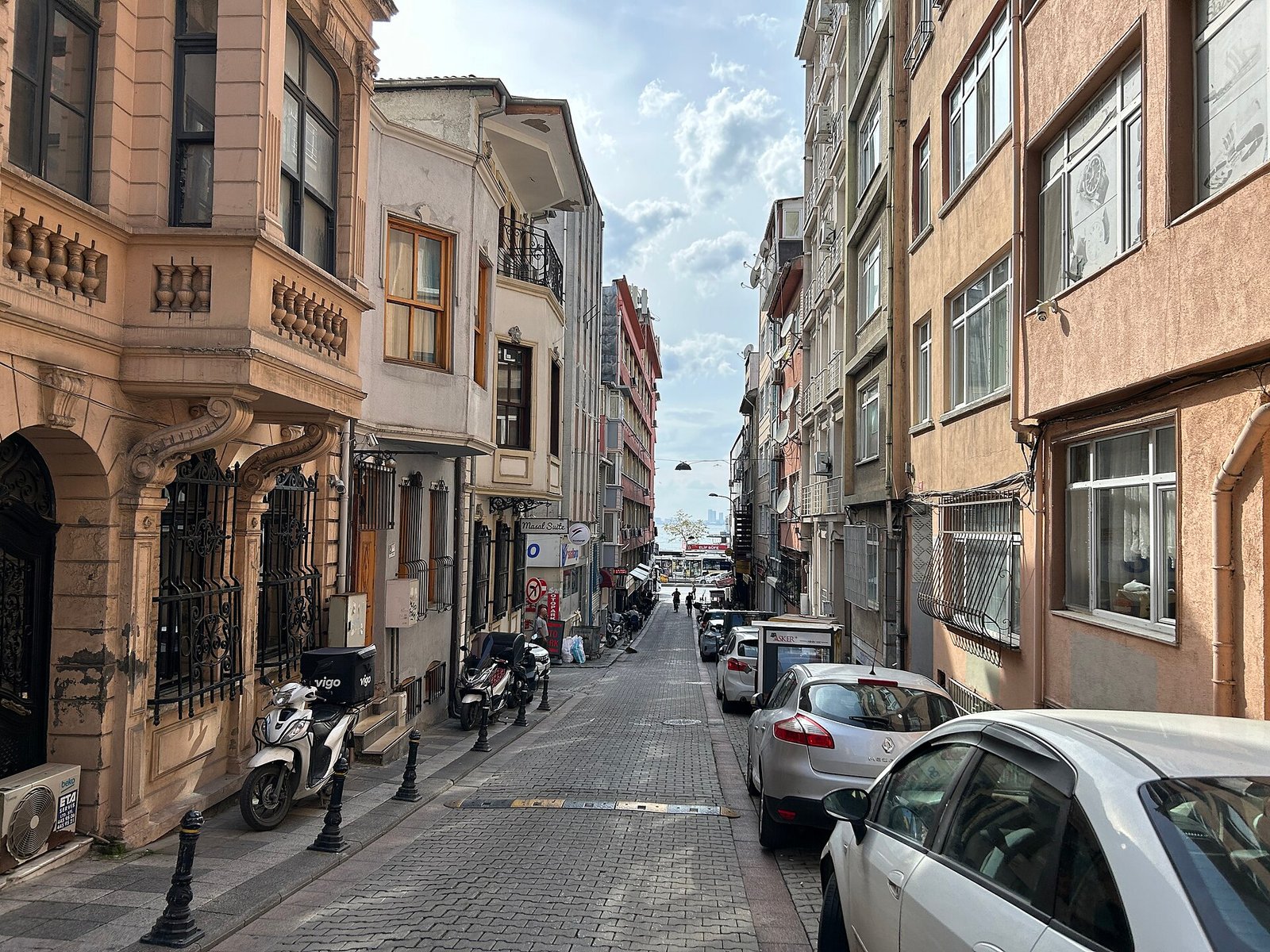 Terrasjes en wandelende mensen in een ontspannen wijk van Istanbul