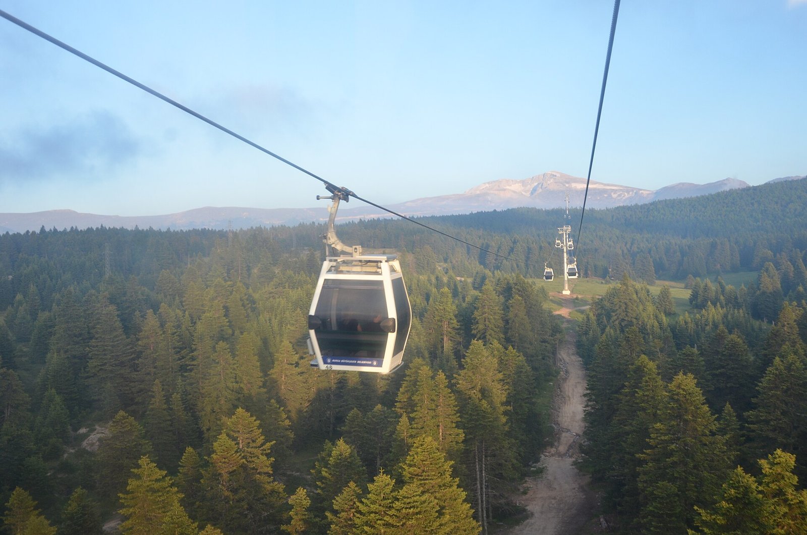 Kabelbaancabine zweeft boven de beboste hellingen van de Uludag bij Bursa