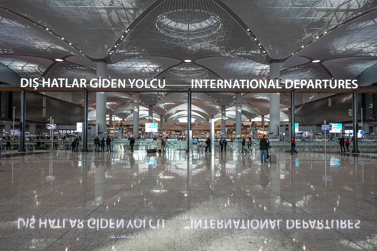 Ruime vertrekhal van Istanbul Airport met reizigers en incheckbalies