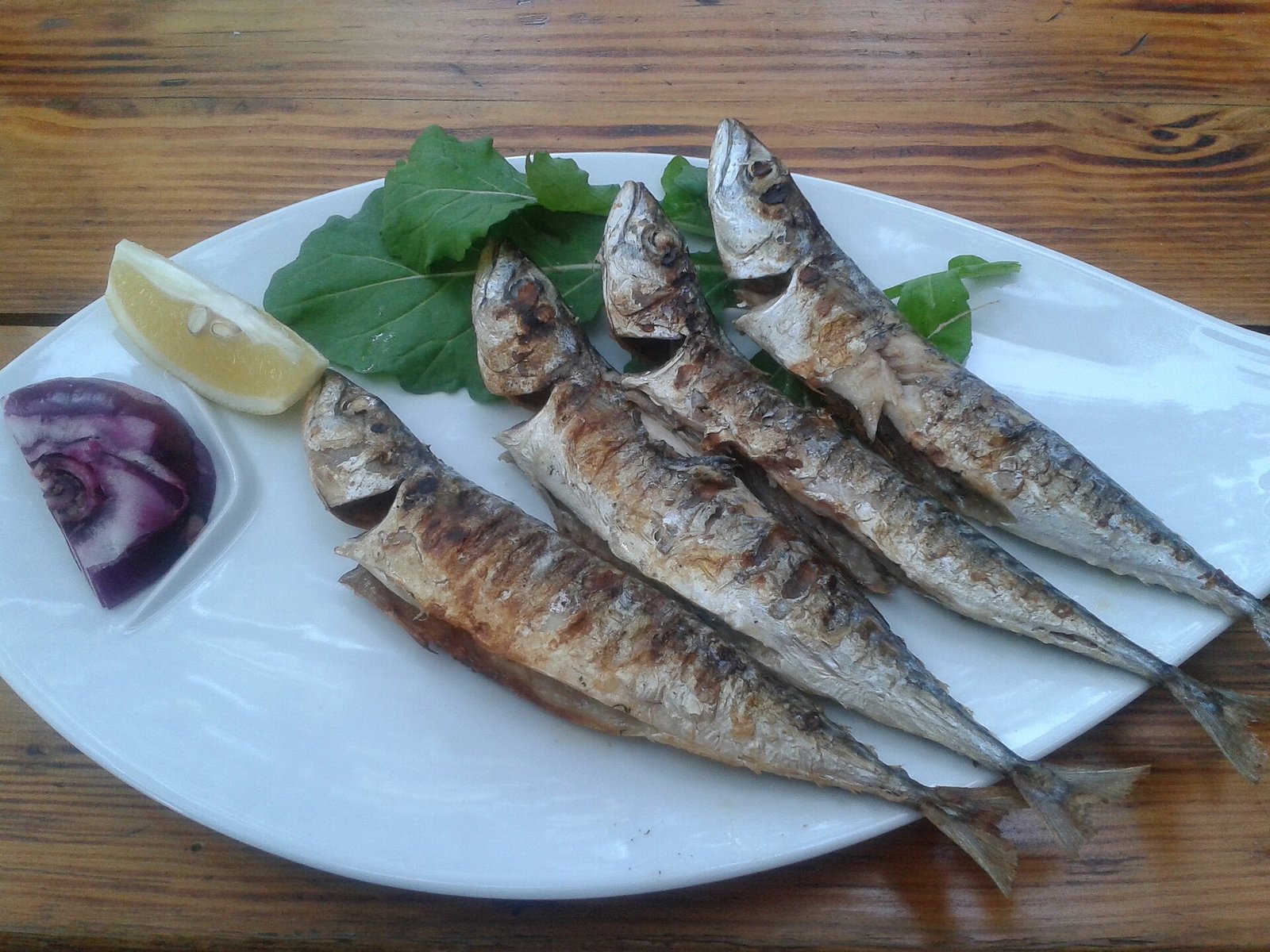 Kleine schaaltjes meze en gegrilde vis op een gedekte tafel